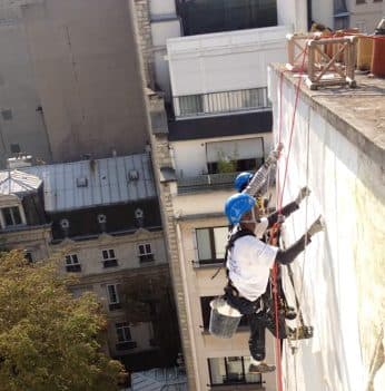 Cordiste intervenant sur une façade d'immeuble parisien