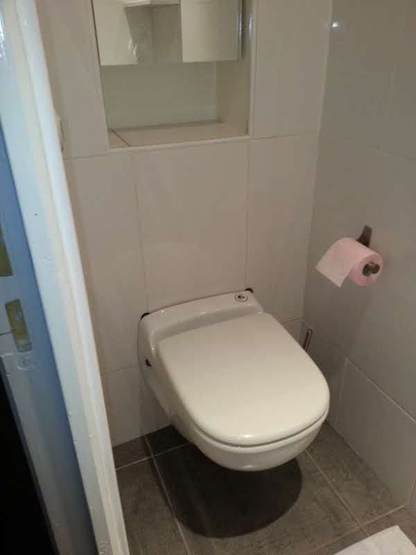 WC suspendu posé dans des toilettes carrelées